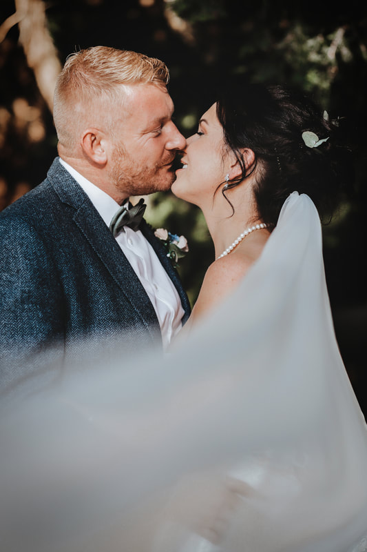The wedding kiss capturing everyone's hearts perfect lighting and embrace of the happy couple  Cambridgeshire Essex Bride and groom happy wedding candid wedding Holmewood hall Gayers Park Sopwell House St Albans Hunton Park Huntingdon 